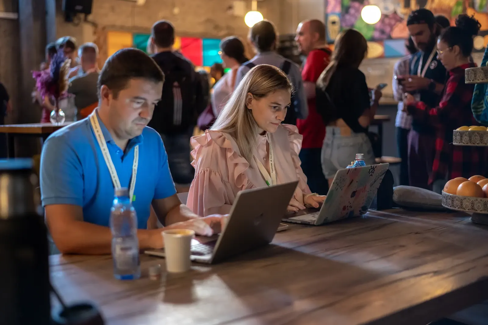 Attendees working on laptops at a shared table in the Friendly.rb 2023 Hack Space