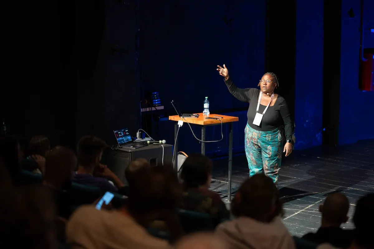 A speaker on stage at Friendly.rb 2025